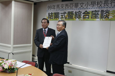 研习班领队王超群校长（左）代表所有团员从侨委会张良民处长（右）手中领取结业证书。