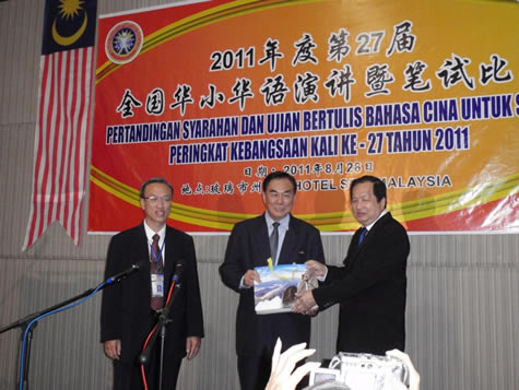 玻州行政议员傅子初医生赠送纪念品予教总主席王超群。左为玻州华校教师会主席梁兆壮。